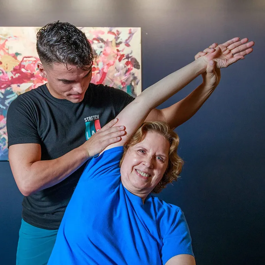 A woman being stretched by a StretchLab team member