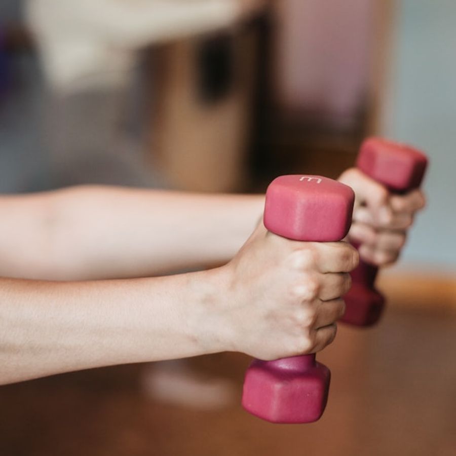 A person holding pink dumbells